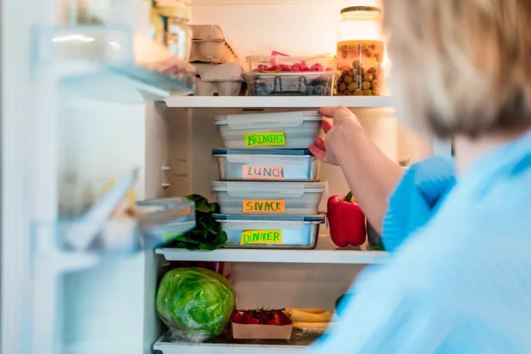woman opening ongoing organized fridge